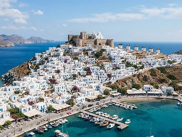 The white hill town of Astypalea Chora crowned by its Venetian castle, with the port below and the sea either side.