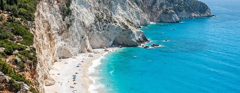 White limestone cliffs dropping to a white pebble beach and turquoise water on the west coast of Lefkada.