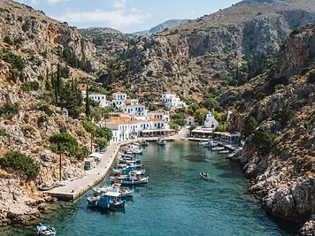 The village of Vathi on Kalymnos at the head of a narrow enclosed inlet, with hills on both sides.