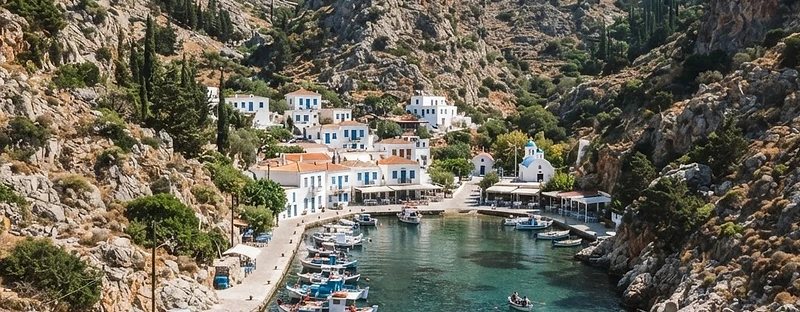 The village of Vathi on Kalymnos at the head of a narrow enclosed inlet, with hills on both sides.