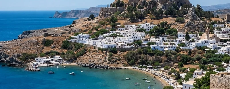 Ancient columns on the acropolis rock above the whitewashed village and bay of Lindos.