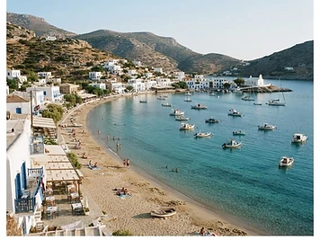 The sheltered inlet and sandy beach at Vathi on Sifnos, ringed by white houses.