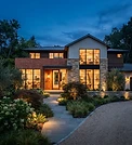 A welcoming modern home exterior with warm lights on