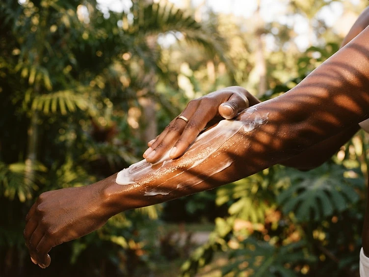 Applying body cream to melanin-rich skin