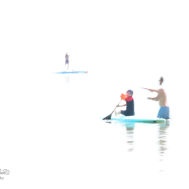 צילום אמנותי בעל אופי מופשט המתעד אנשים על גבי גלשני סאפ בלב ים. השימוש בערכי חשיפה קיצוניים יוצר רקע לבן ובוהק, המעניק לדמויות מראה אוורירי ומרחף. טשטוש מכוון בשילוב עם תאורה חזקה מטשטשים את גבולות המים והשמיים, ויוצרים תחושת שקט, ניקיון חזותי ומינימליזם מרתק בתוך מרחב ימי פתוח.