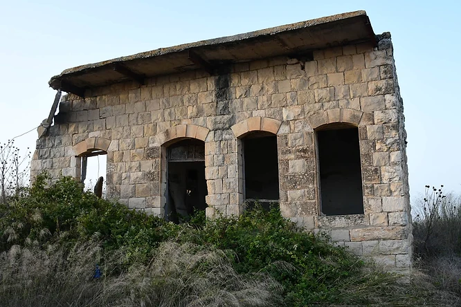 צילום דוקומנטרי מרתק של מבנה אבן עתיק ונטוש, המתאפיין באדריכלות כפרית קלאסית. המבנה מוקף צמחייה פראית המשתלטת על חזיתו, מה שמעניק לו מראה נוסטלגי ומסתורי. התאורה הרכה בשעות אחר הצהריים מחמיאה למרקם האבן המחוספס, בעוד שעדשת ה-18 מ"מ תופסת קומפוזיציה רחבה המדגישה את בדידות המבנה בלב הסביבה הטבעית.