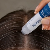 The rollerball serum rolled along the part line of a scalp