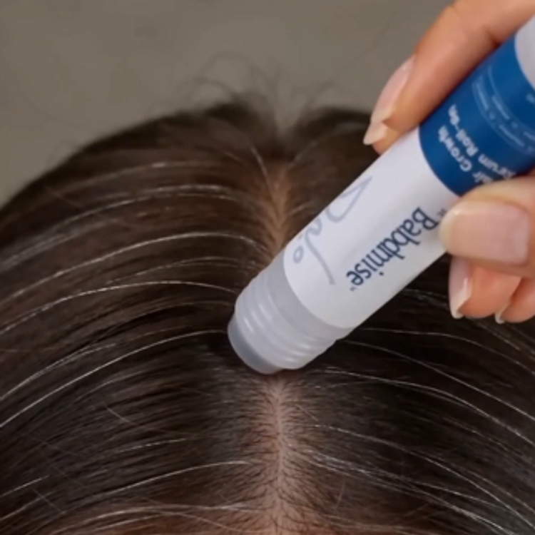 The rollerball serum rolled along the part line of a scalp
