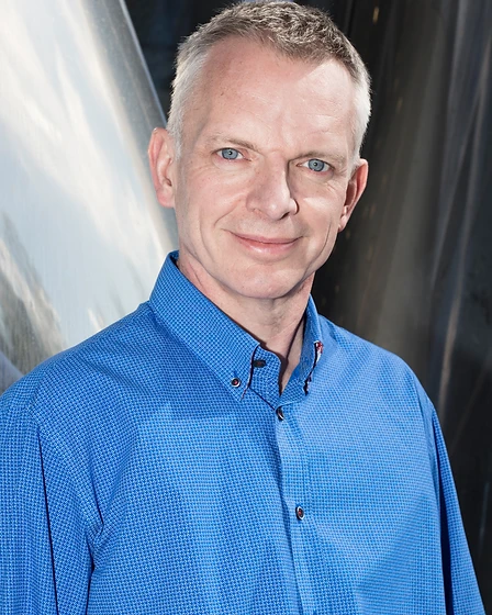 Eamon Ray, founder of Healexus, standing in a serene modern interior, calm and contemplative