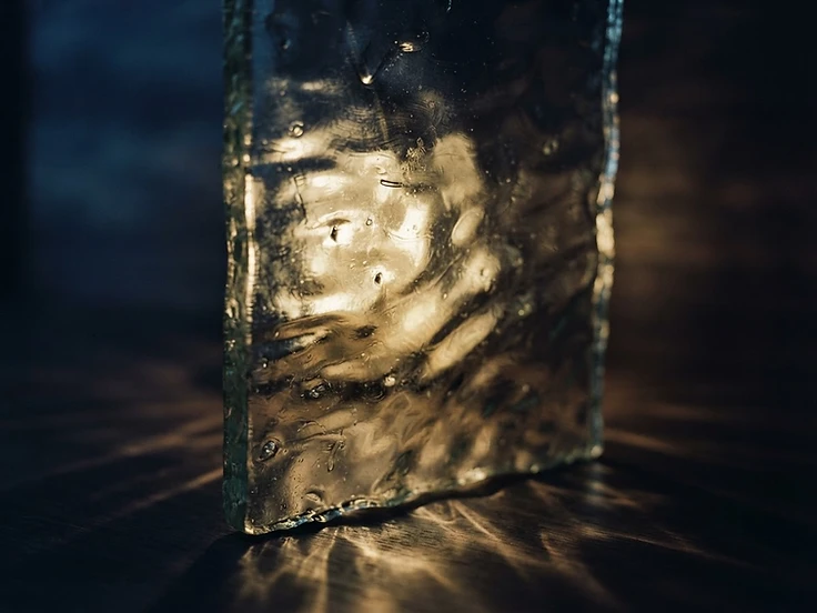 Abstract light refracting through textured glass — a quiet visual metaphor for energy