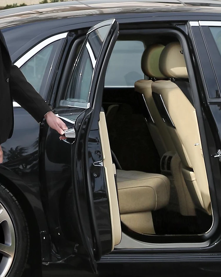 Professional chauffeur in white gloves opening the door of a luxury vehicle in Orlando