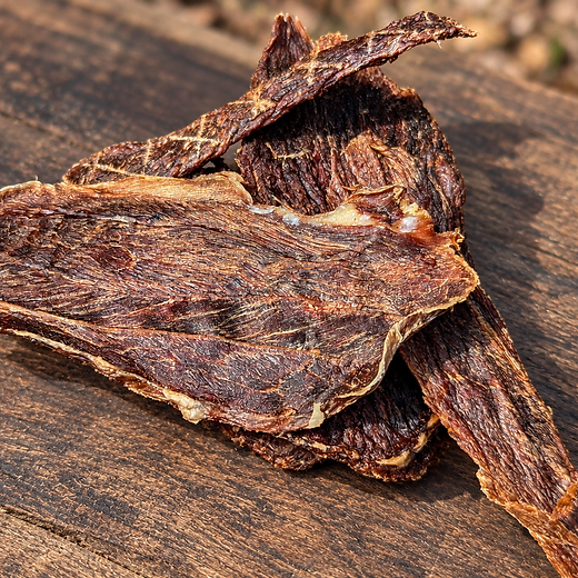 Air-dried venison jerky on rustic wood