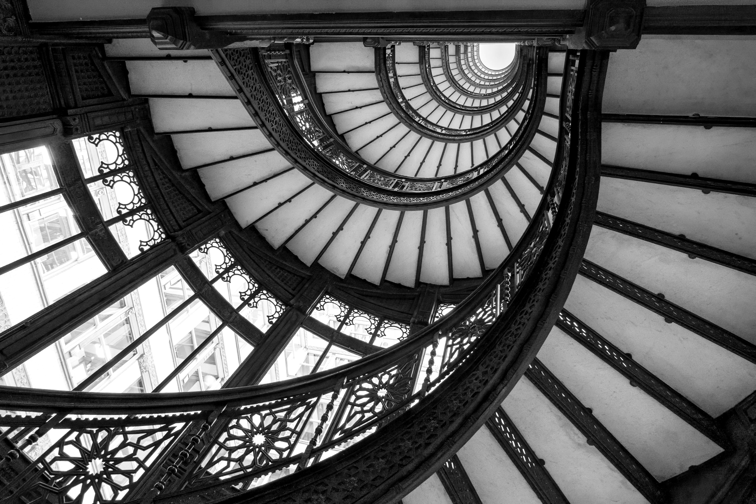 Spiral staircase inside the Rookery Building on LaSalle Street in Chicago, black and white.