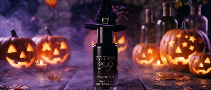 A skincare bottle wearing a tiny black witch hat on a wooden table surrounded by glowing jack-o-lanterns, purple fog and drifting autumn leaves