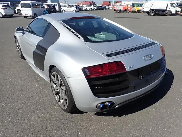 Silver Audi R8 viewed from the rear quarter in an outdoor vehicle lot.