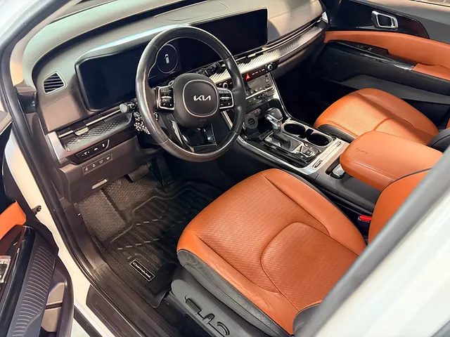 Kia interior with tan front seats, black dashboard, steering wheel and centre console.
