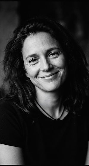 A person smiling gently, wearing a Just Stay t-shirt
