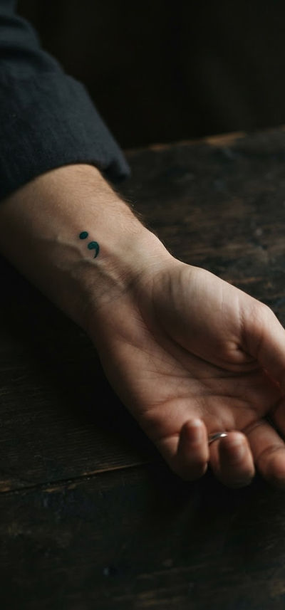 A hand with a semicolon, a symbol of choosing to stay