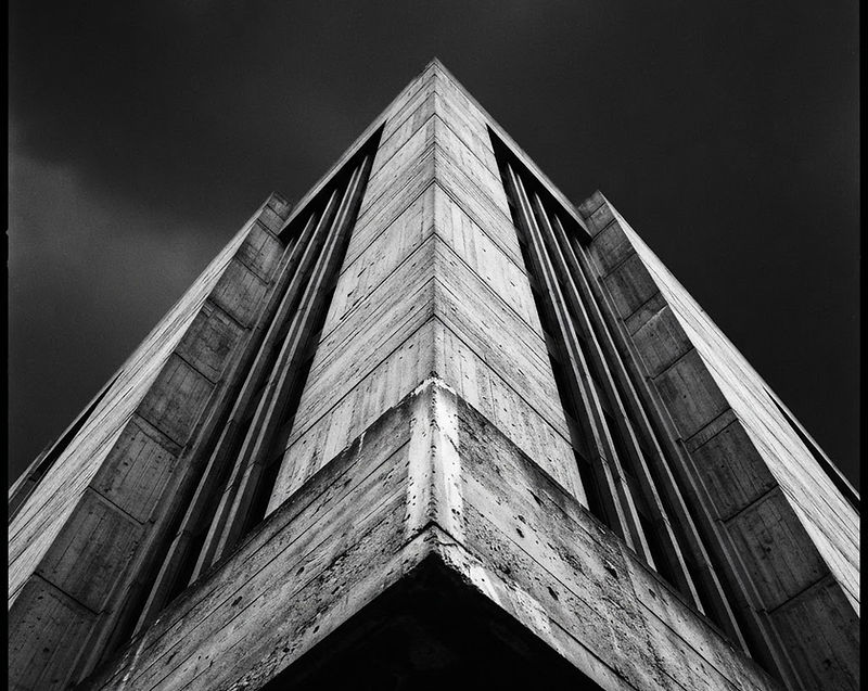 Monolithic concrete architecture rising against a dark sky