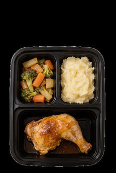 Top-down view of a three-compartment meal tray with roasted chicken, mashed potatoes, and vegetables