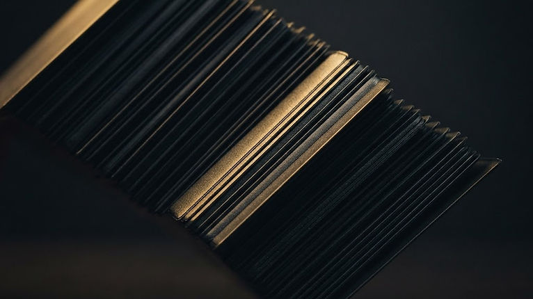 Trading card in a penny sleeve and toploader beside a padded bubble mailer on a dark table