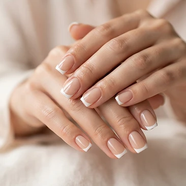 Classic French manicure on softly squared nails with a sheer nude base and crisp white tips