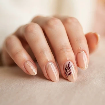 Nude nails with fine gold line work and a delicate botanical accent nail
