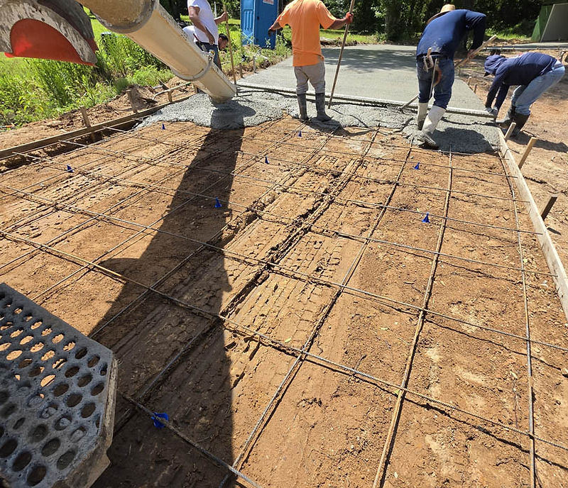 Torres Concrete crew pouring and spreading a slab over steel reinforcement