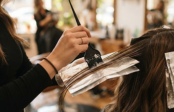 Επαγγελματίας εφαρμόζει τεχνική balayage σε καστανά μαλλιά