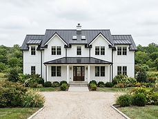 White modern farmhouse with a charcoal standing seam metal roof