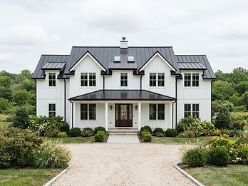 White modern farmhouse with a charcoal standing seam metal roof