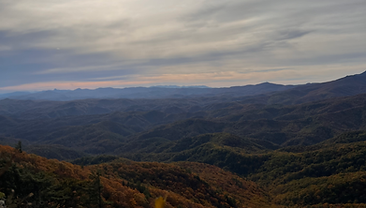 Morning sun above layered ridges in autumn