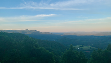 A wide overlook of green ridges and valley farmland in the Blue Ridge