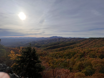 Sun breaking over a valley of fall color in the Blue Ridge