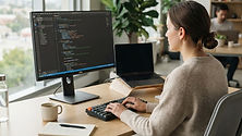 Modern professional office desk with a screen displaying computer code, symbolizing web security.