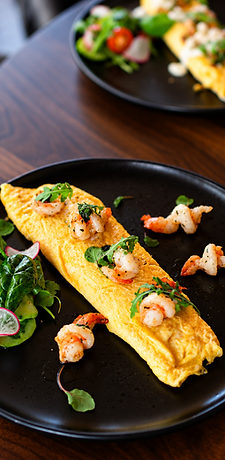 Shrimp omelet served on a black plate