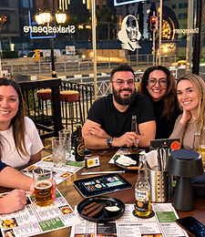 Customers enjoying drinks by the window with the Shakespeare logo
