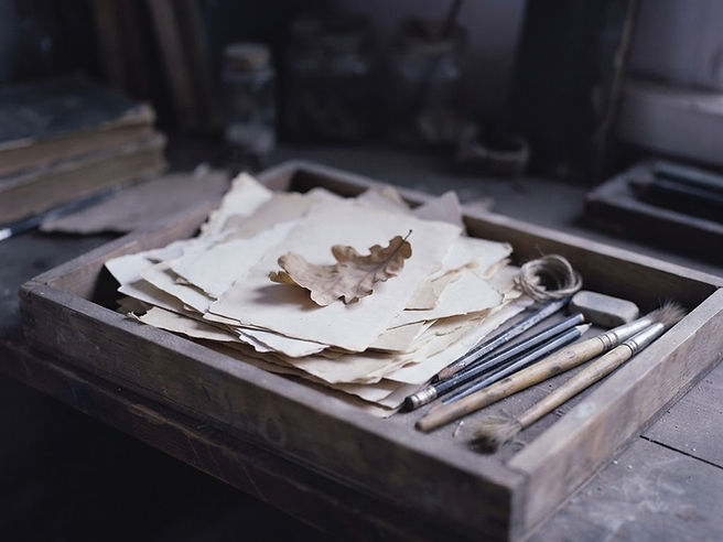 A tray of blank paper scraps and unused supplies set aside in dim, dust-faded light