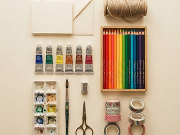 Art supplies arranged on a cream background