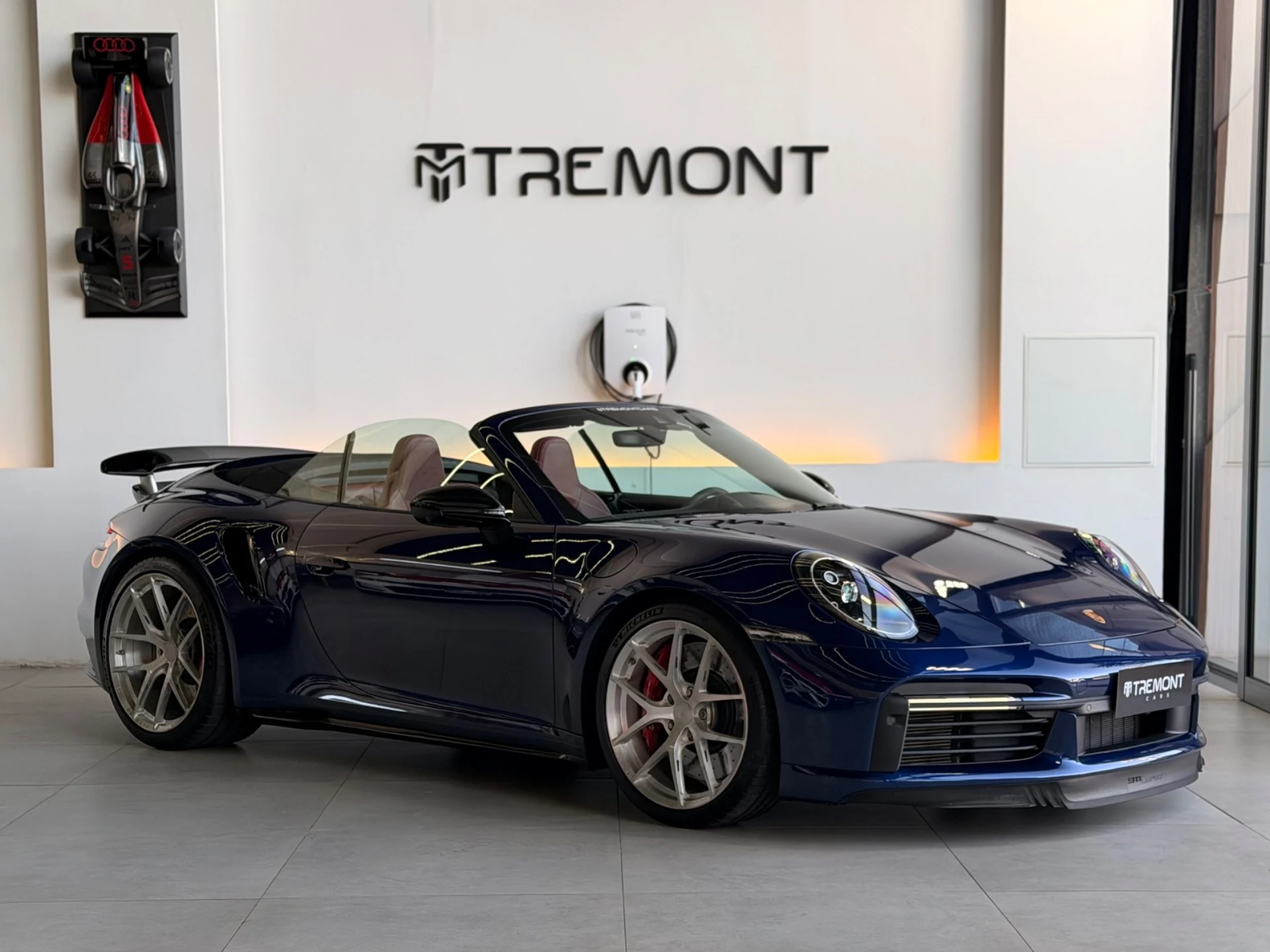 Porsche 911 Turbo S Cabriolet azul no showroom da Tremont Cars