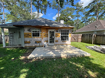 Rear exterior with exposed house wrap and an uncovered concrete patio.
