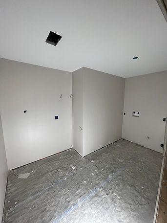 Laundry room with an unfinished floor and open electrical fixture cutouts.