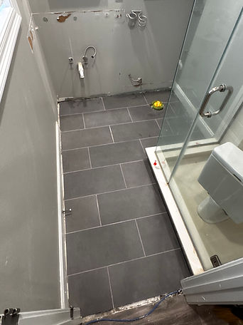 New gray rectangular floor tiles installed in the same bathroom.