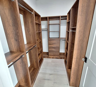 Walk-in closet with custom wood shelving, hanging rails and a central drawer unit
