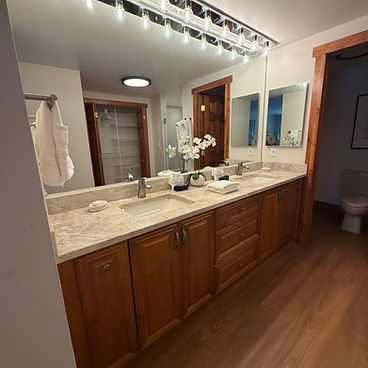 Cleaned master bathroom with marble vanity, Edison bulb lighting, and fresh white towels — professional housekeeping result by Elite Property Management