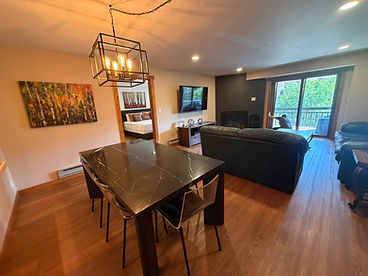 Deep-cleaned mountain home living and dining area with marble table, leather sofa, and accent fireplace wall — professional housekeeping result by Elite Property Management