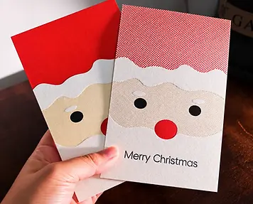 Two printed Christmas cards with layered Santa design