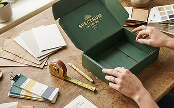 Material swatches, foil samples and a mailer box on a sourcing specialist's desk