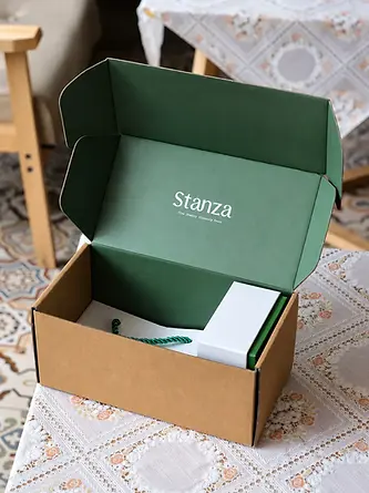 Open kraft mailer box with a green printed interior and coordinated packaging