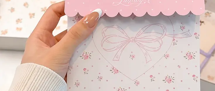 Coordinated floral packaging card held in front of mailer boxes